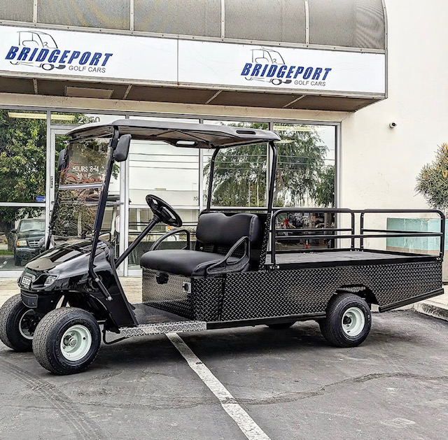 black flatbed golf car parked in front of Bridgeport Golf Cars showroom