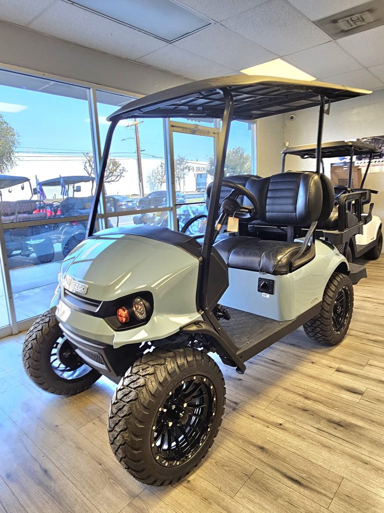 white trimmed four seater golf car inside the Bridgeport Golf Cars showroom